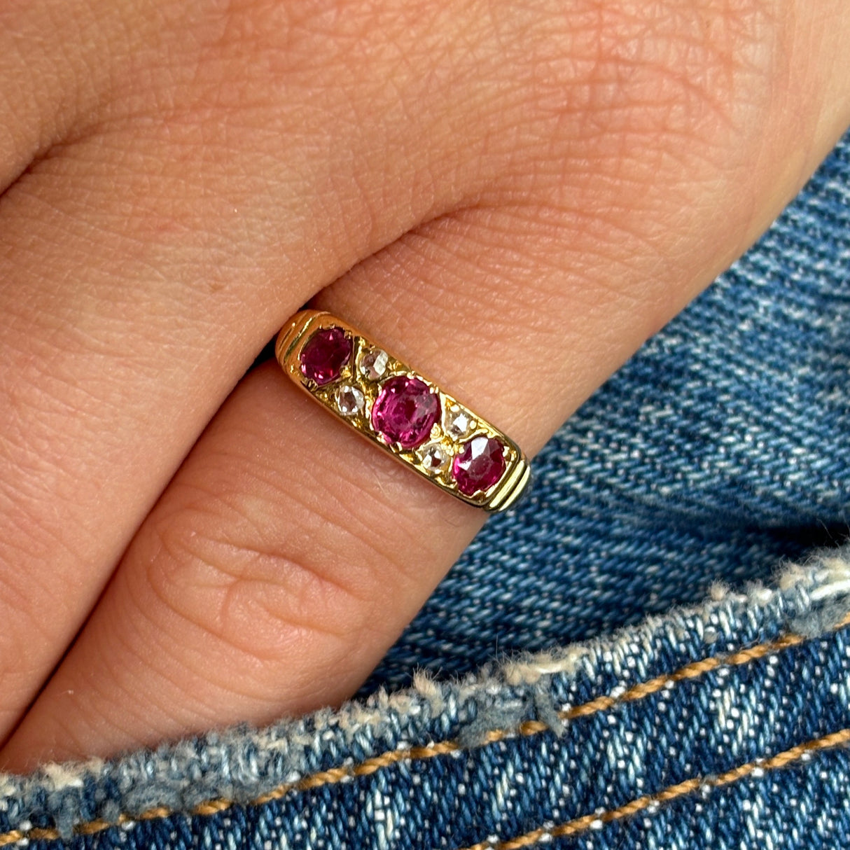 Antique, Edwardian ruby & diamond three-stone ring worn on hand.