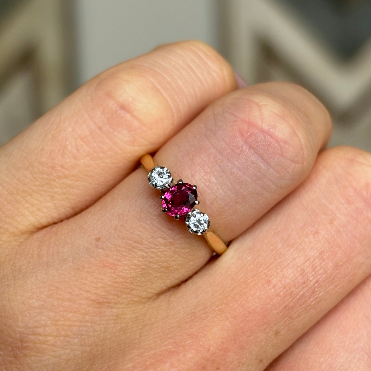 Antique, Edwardian ruby & diamond three-stone ring worn on hand.