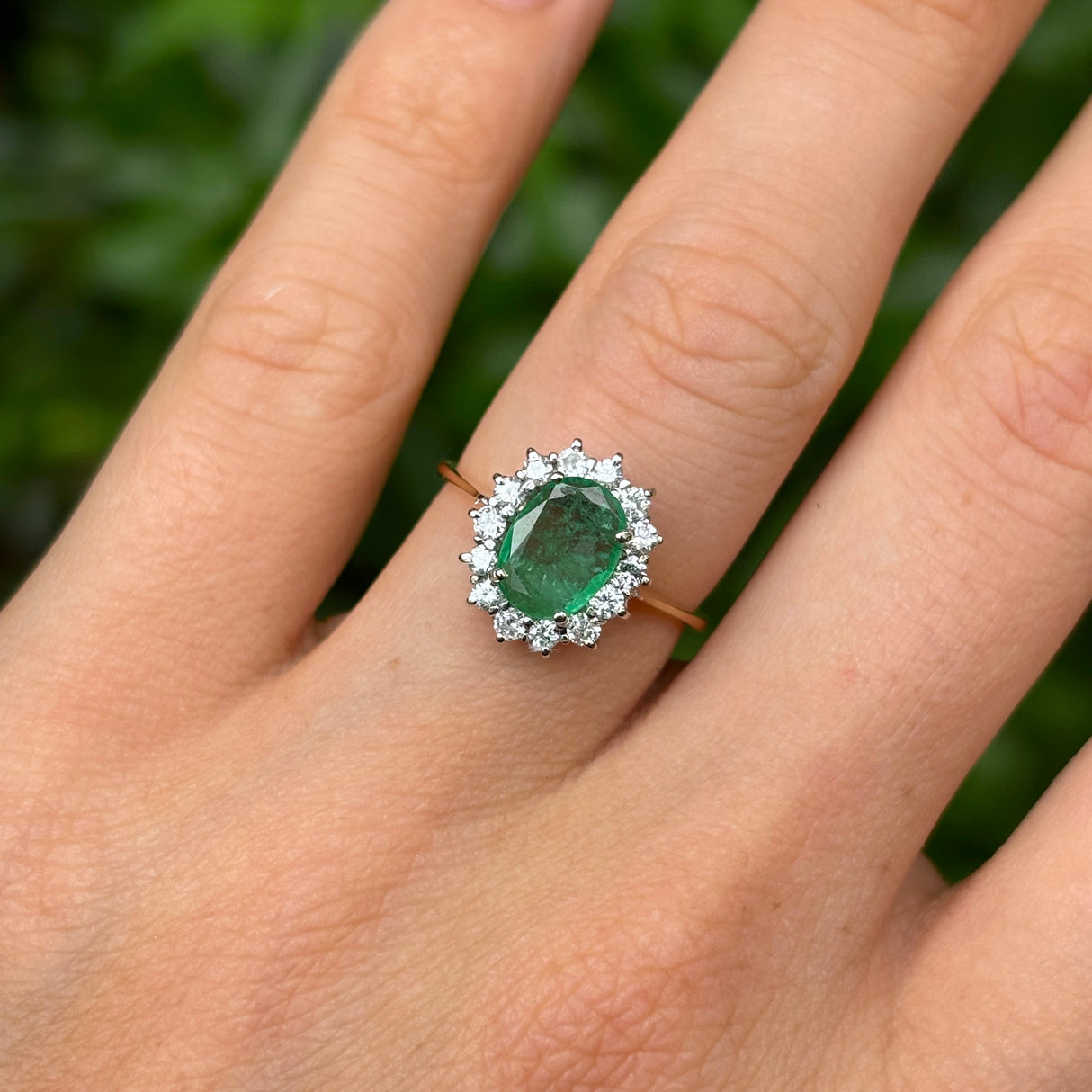 Vintage, 1990s emerald & diamond cluster ring worn on hand.