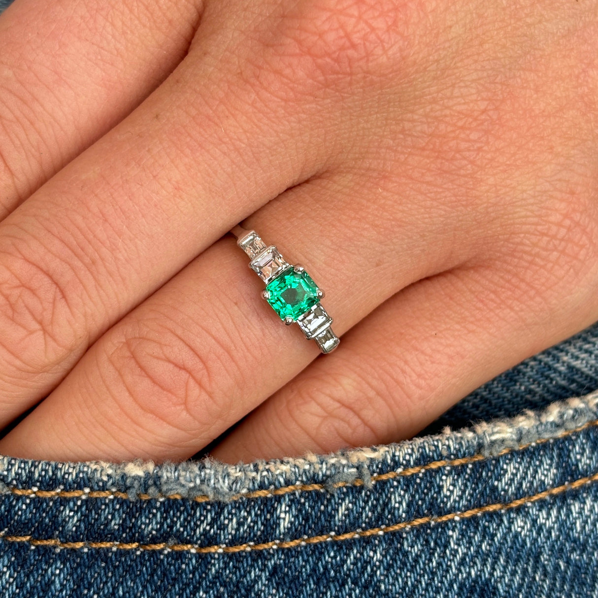 Vintage, Art Deco emerald & diamond five-stone ring worn on hand.