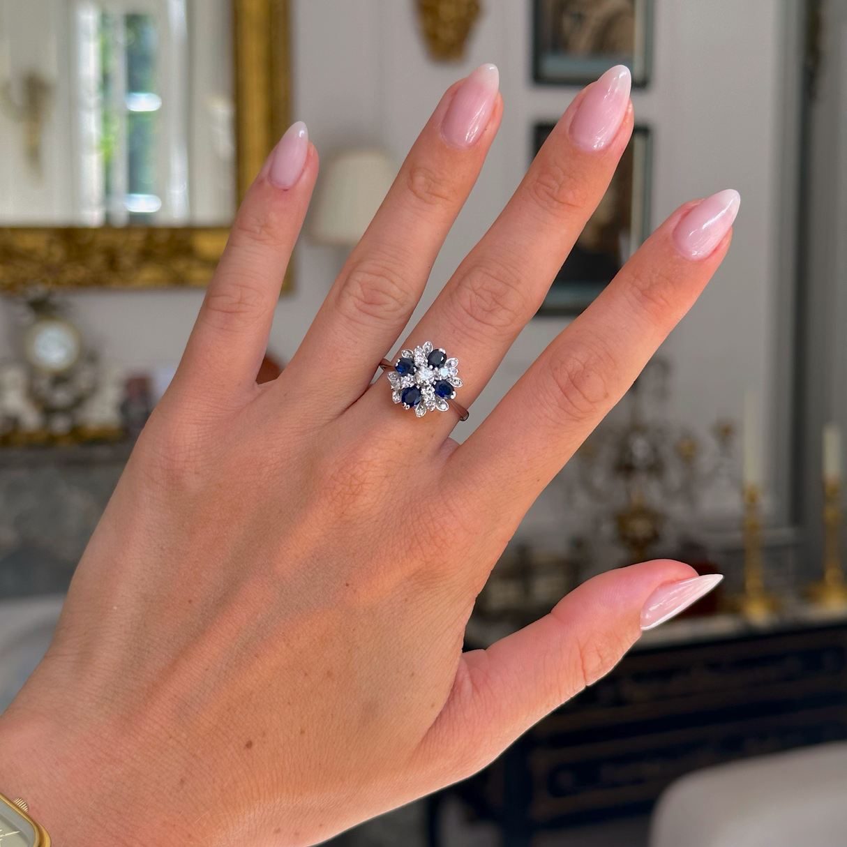 Sapphire and diamond cluster ring from 80s, worn on hand, front view.