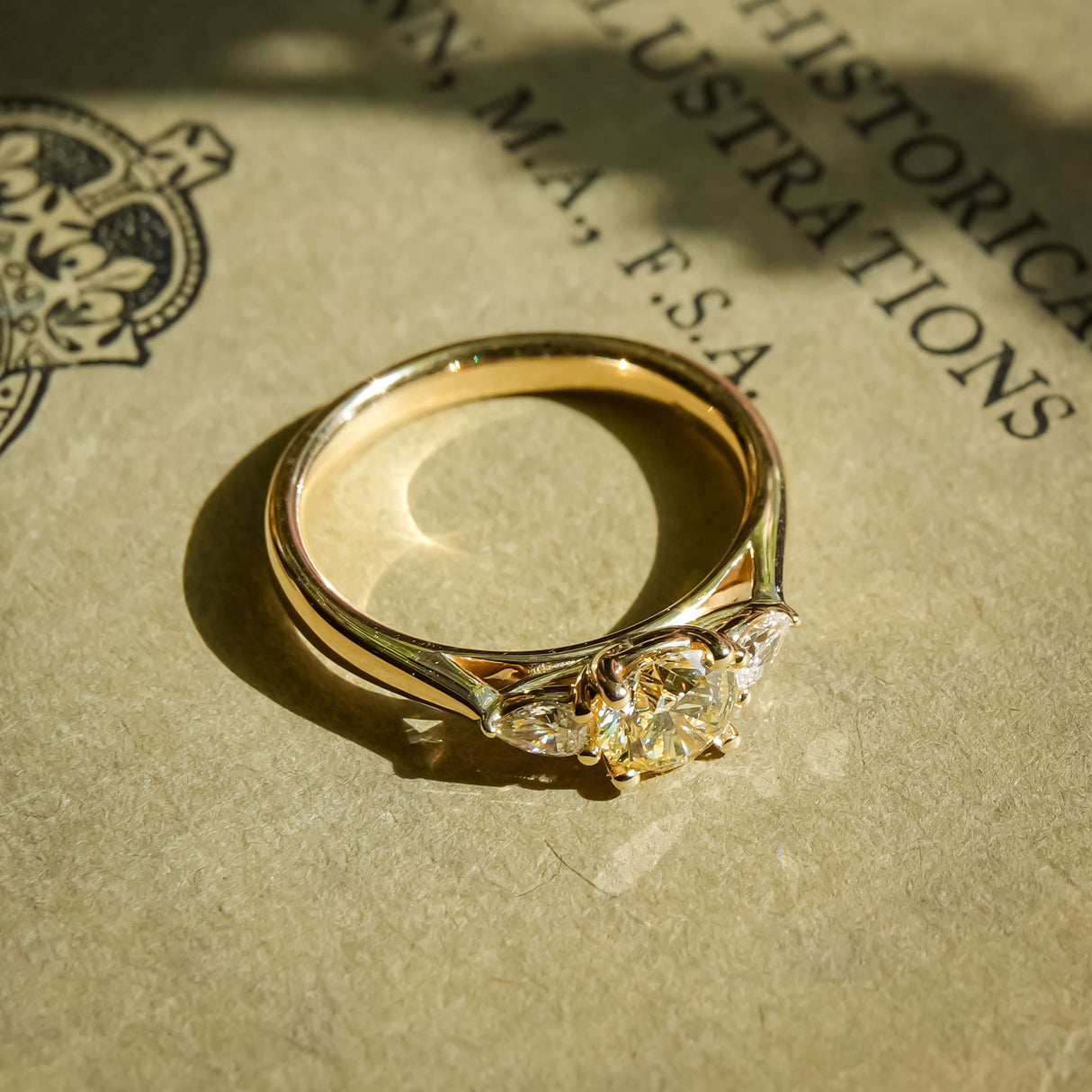Champagne diamond and white diamond three stone engagement ring in yellow gold band