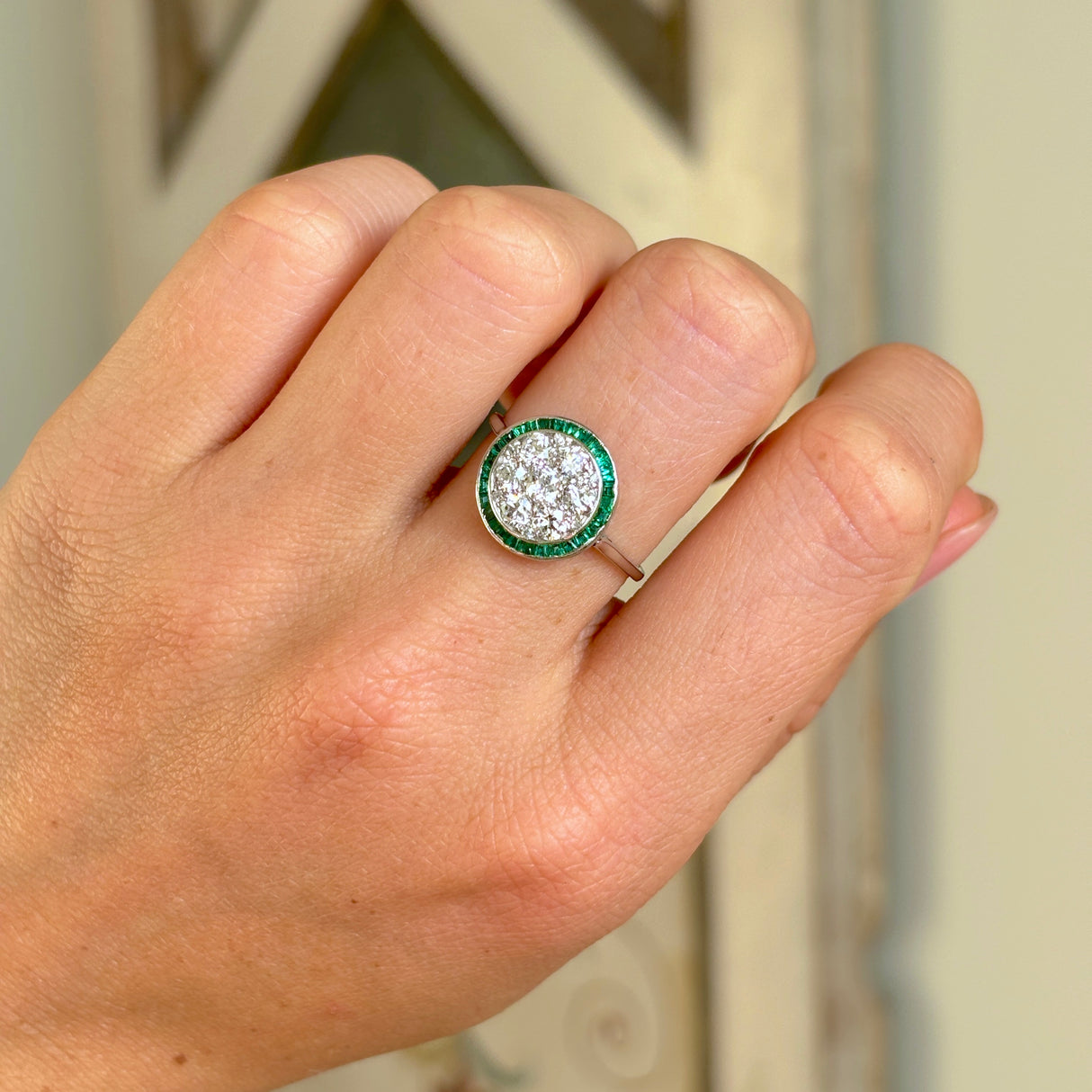 Vintage, Art Deco emerald & diamond target cluster ring worn on hand.
