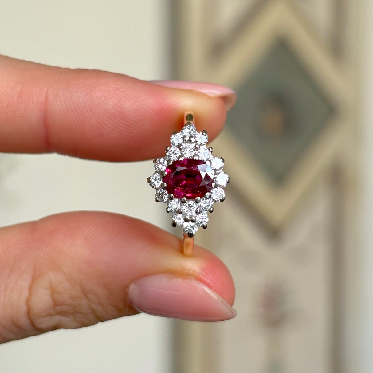 Vintage, 1970s ruby & diamond cluster ring held in fingers.