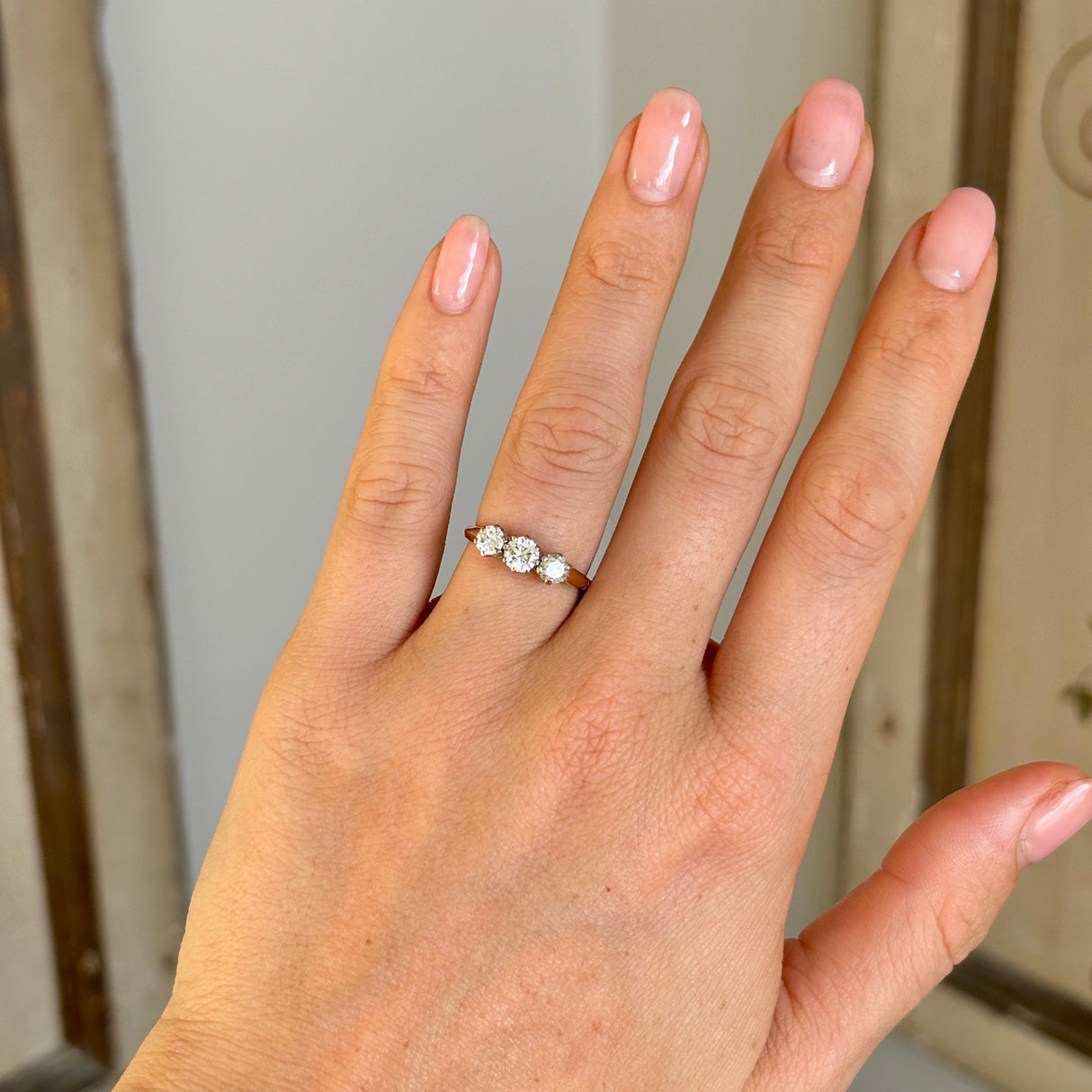 Vintage, 1970s three-stone diamond ring worn on hand.