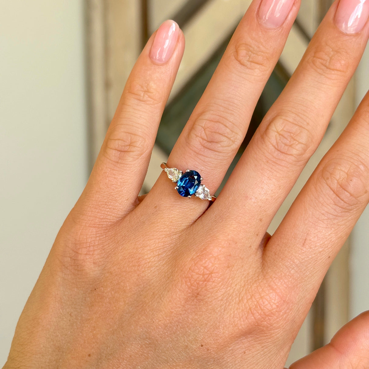 Vintage, sapphire & diamond three-stone ring worn on hand.