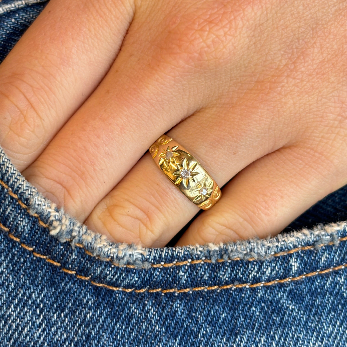Vintage, 1950s three-stone diamond ring worn on hand.