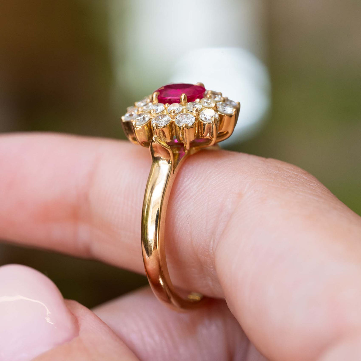 Side detail of a vintage 1980s Burmese ruby and diamond cluster ring in yellow gold.