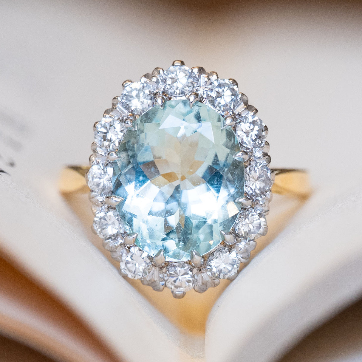 A vintage, 1960s aquamarine & diamond cluster engagement ring with a yellow gold band.