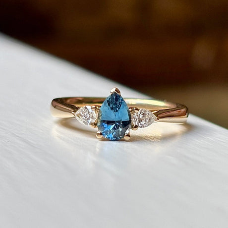Pear-cut teal sapphire & diamond three-stone ring