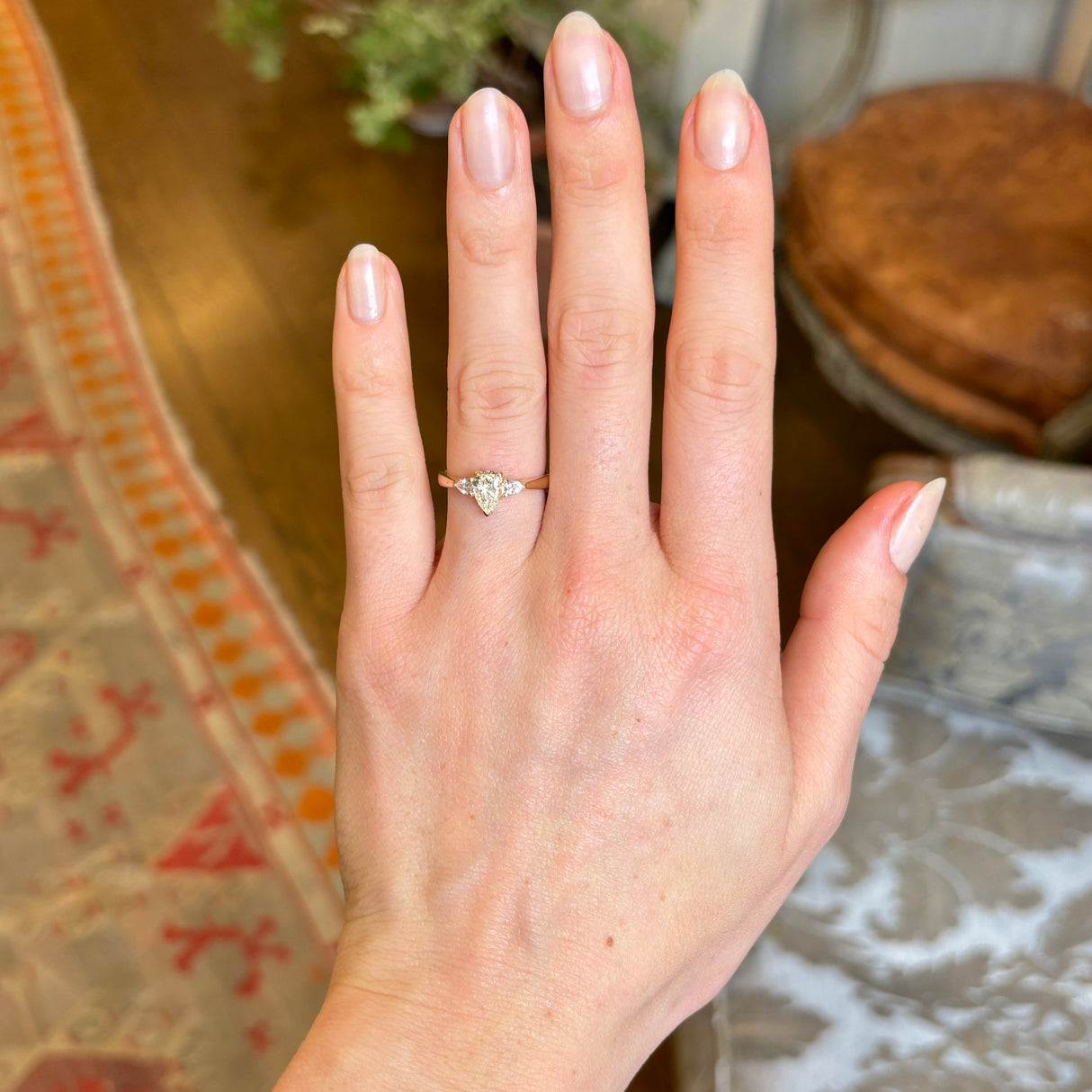 Ethical Pear-Cut Central Diamond With Pear-cut Diamond Shoulders Three-Stone Wed-Fit Engagement Ring View on Hand. Distant View.