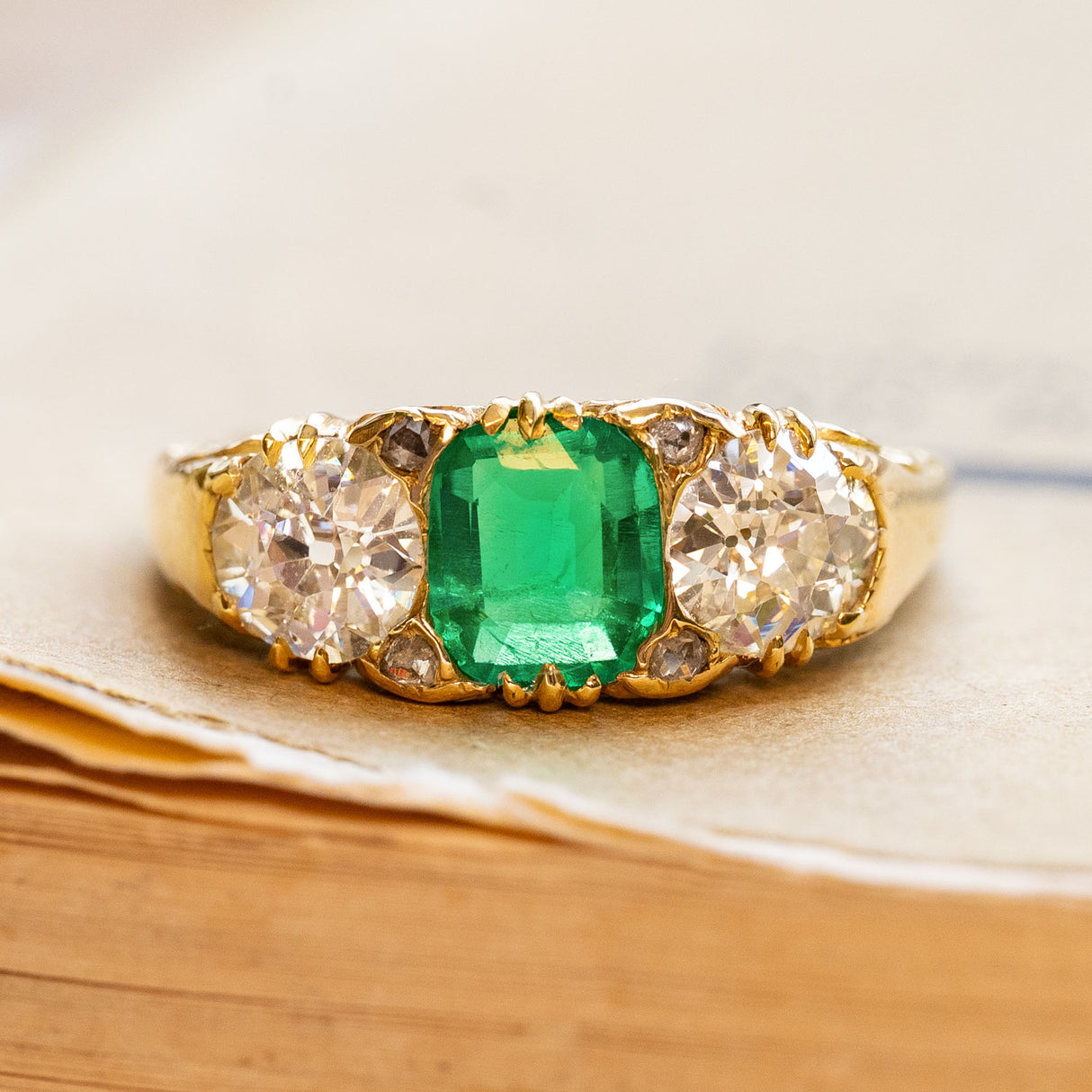 Antique Victorian emerald and diamond three-stone ring in yellow gold.