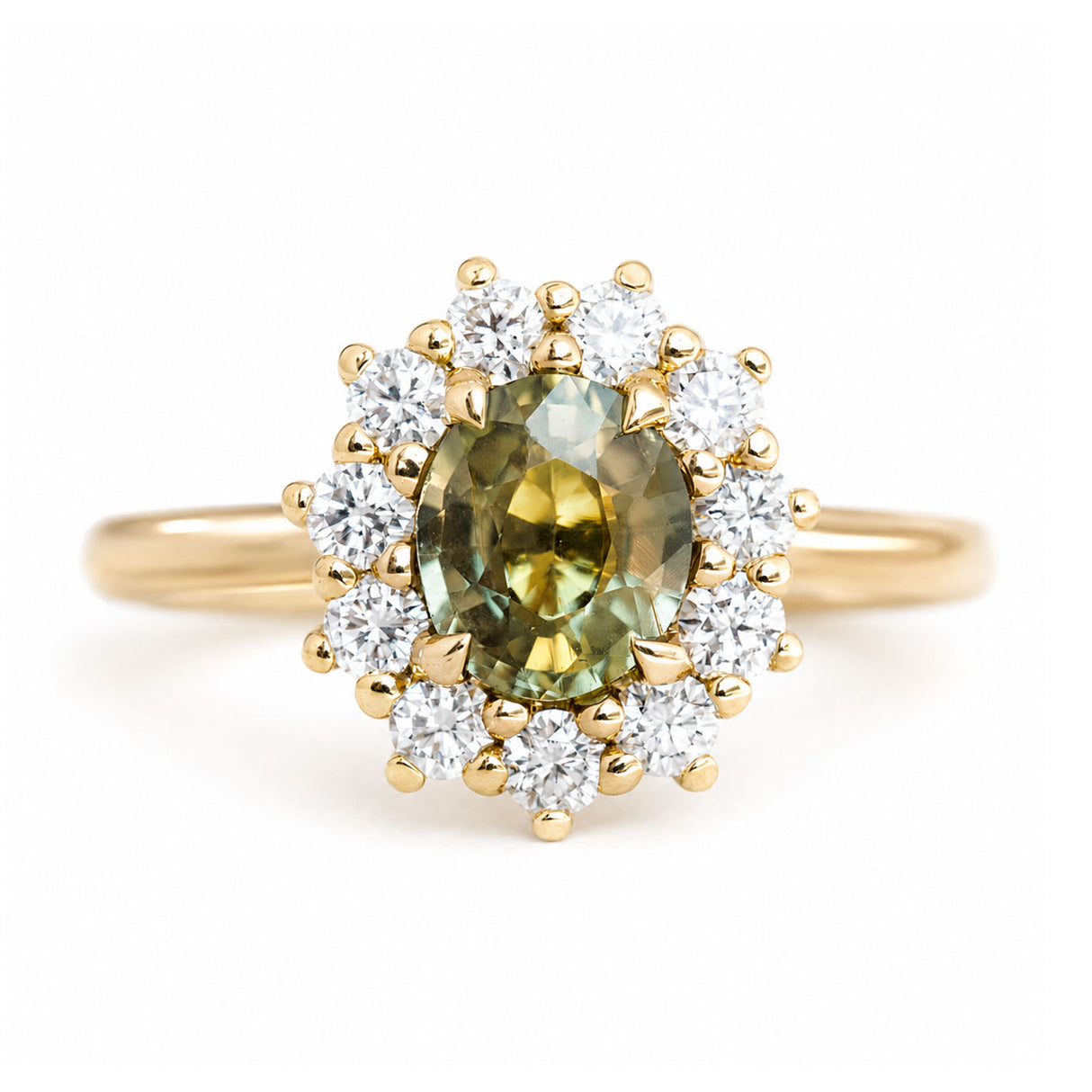 An antique-inspired, Green sapphire and diamond halo cluster engagement ring set in 14ct yellow gold.