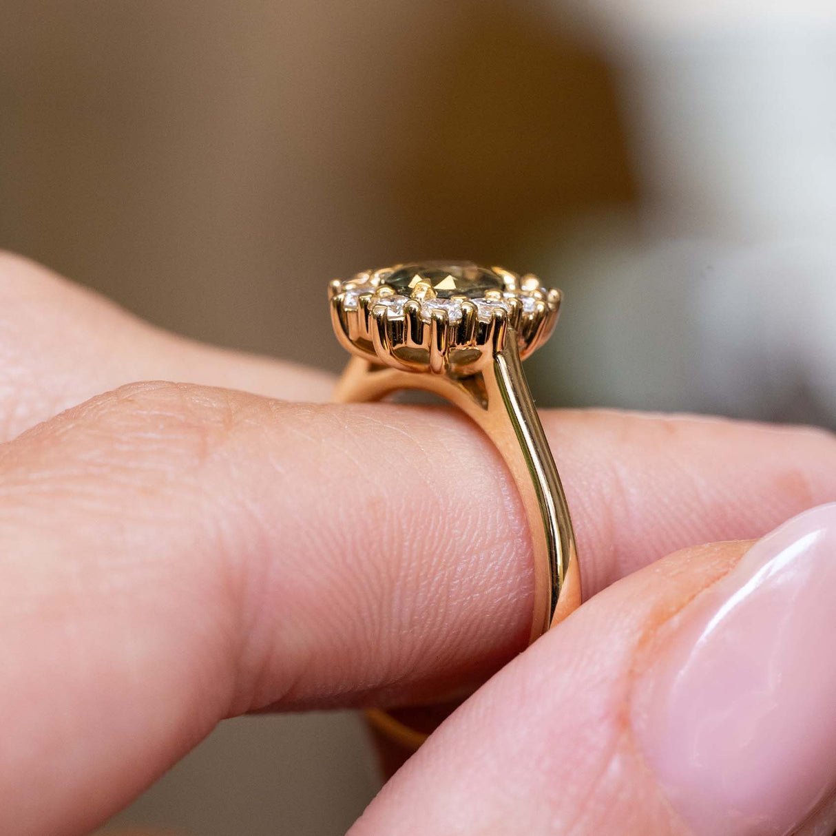 Detailed side view of an antique-inspired green sapphire and diamond cluster engagement ring crafted in yellow gold.