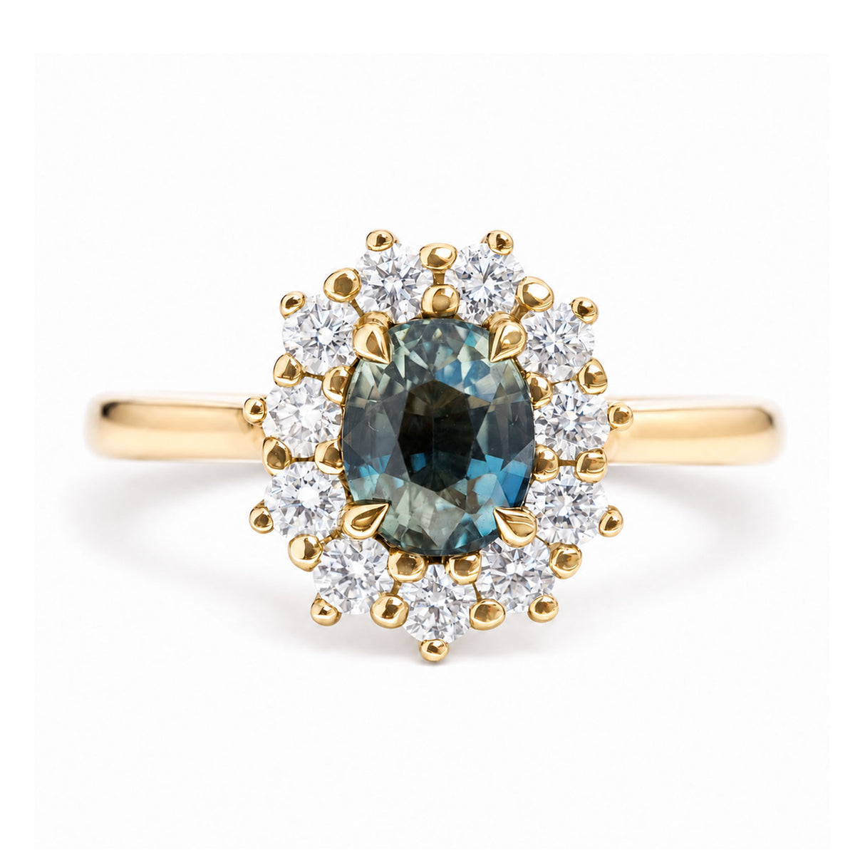 An antique-inspired, teal sapphire and diamond halo cluster engagement ring in yellow gold.