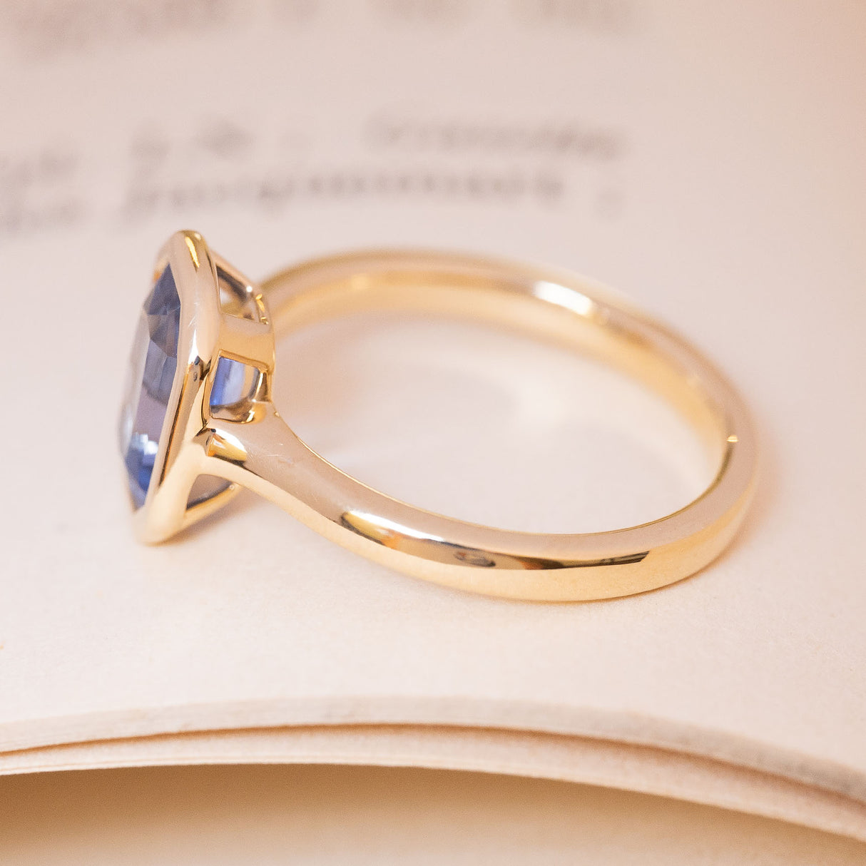 Vintage-inspired blue sapphire solitaire engagement ring in yellow gold from the side profile.