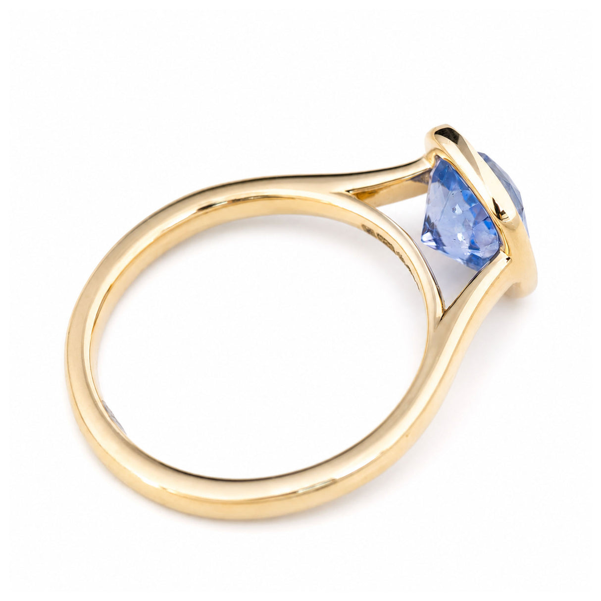 A top-back view of a vintage-inspired, yellow gold solitaire engagement ring with a blue-purple cushion-cut sapphire.