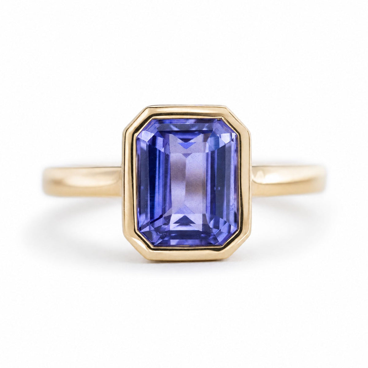 An antique-inspired bright indigo-blue sapphire solitaire engagement ring in yellow gold.