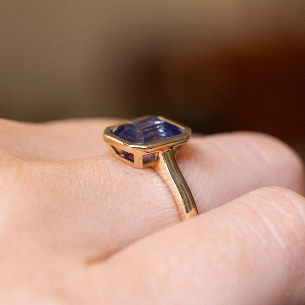 Side detail of an antique-inspired indigo blue sapphire solitaire engagement ring in yellow gold.