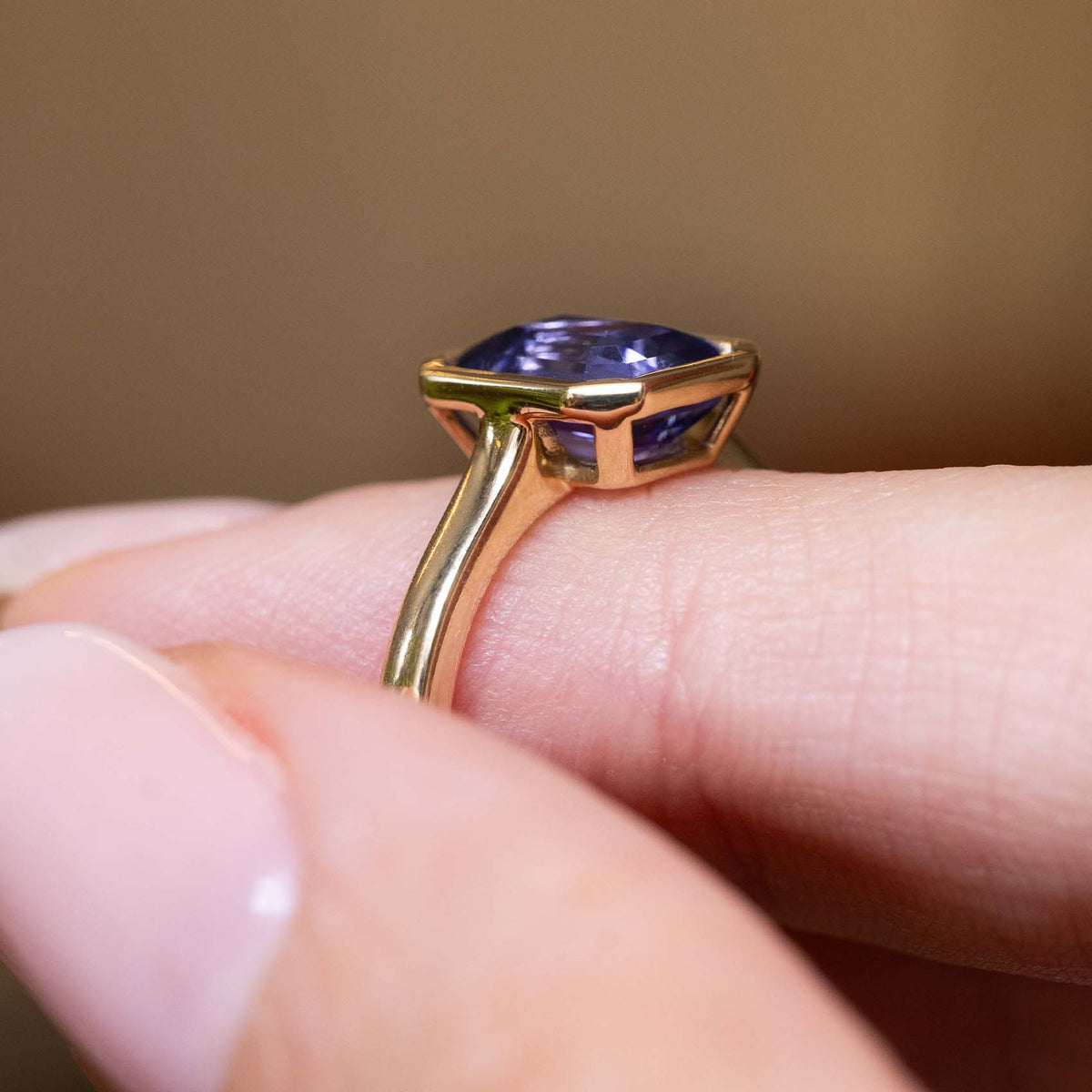 Profile view of an antique-inspired indigo blue sapphire solitaire engagement ring crafted in yellow gold.