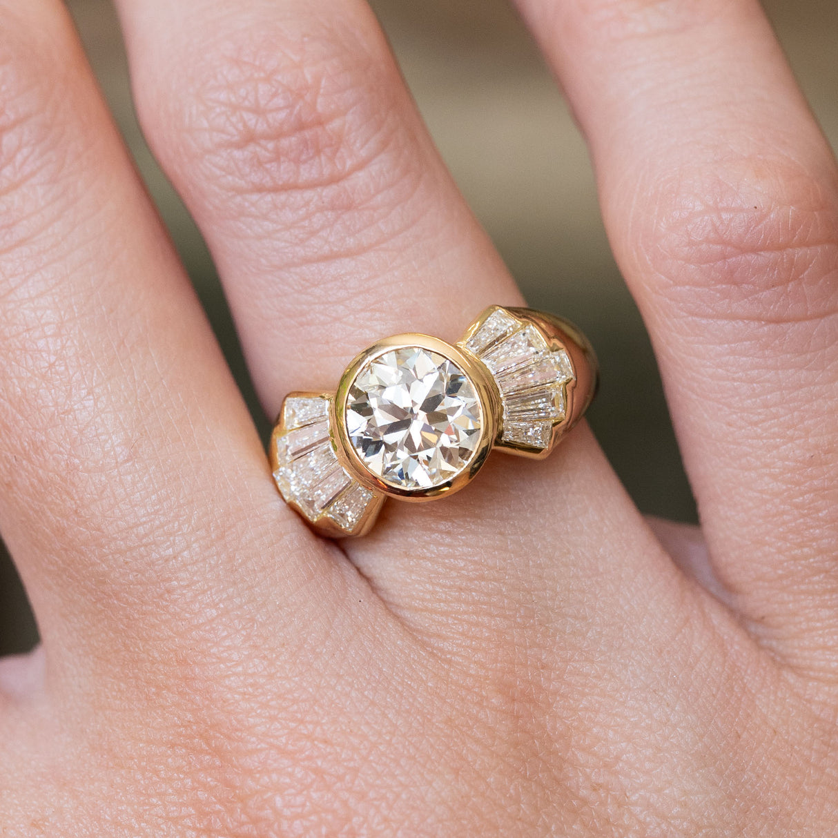 Vintage 1950s old-cut diamond fan engagement ring shown on the finger, highlighting the old-cut diamond and tapered baguette diamond fan design.