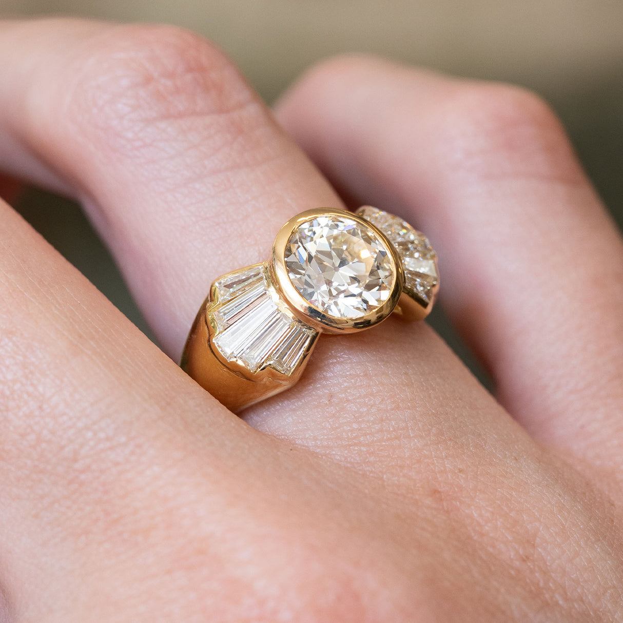 Three-quarter view of a vintage 1950s old-cut diamond fan engagement ring showcasing the fan-shaped baguette diamond shoulders.