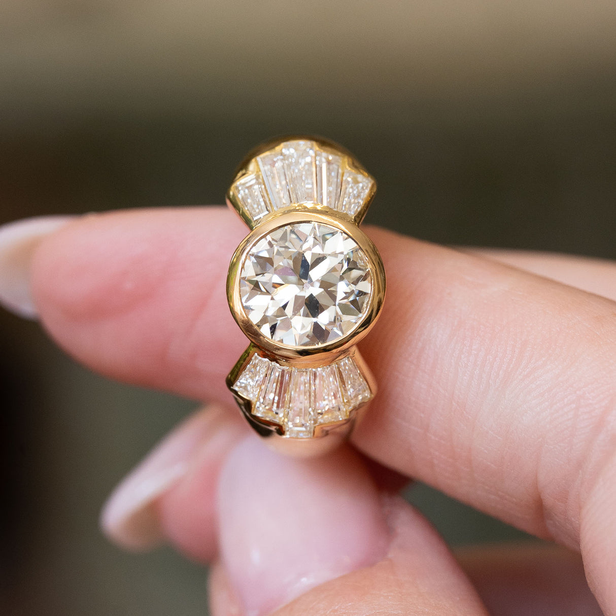 Front view of a vintage old-cut diamond fan engagement ring featuring an old-cut diamond framed by tapered baguette diamond shoulders.