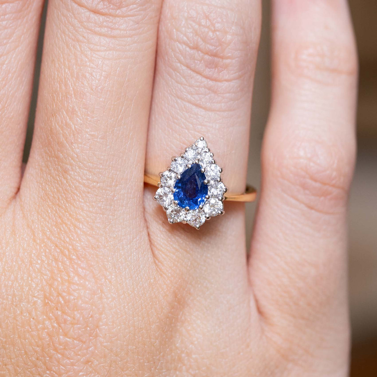 Close-up of a 1980s sapphire and diamond engagement ring on the finger