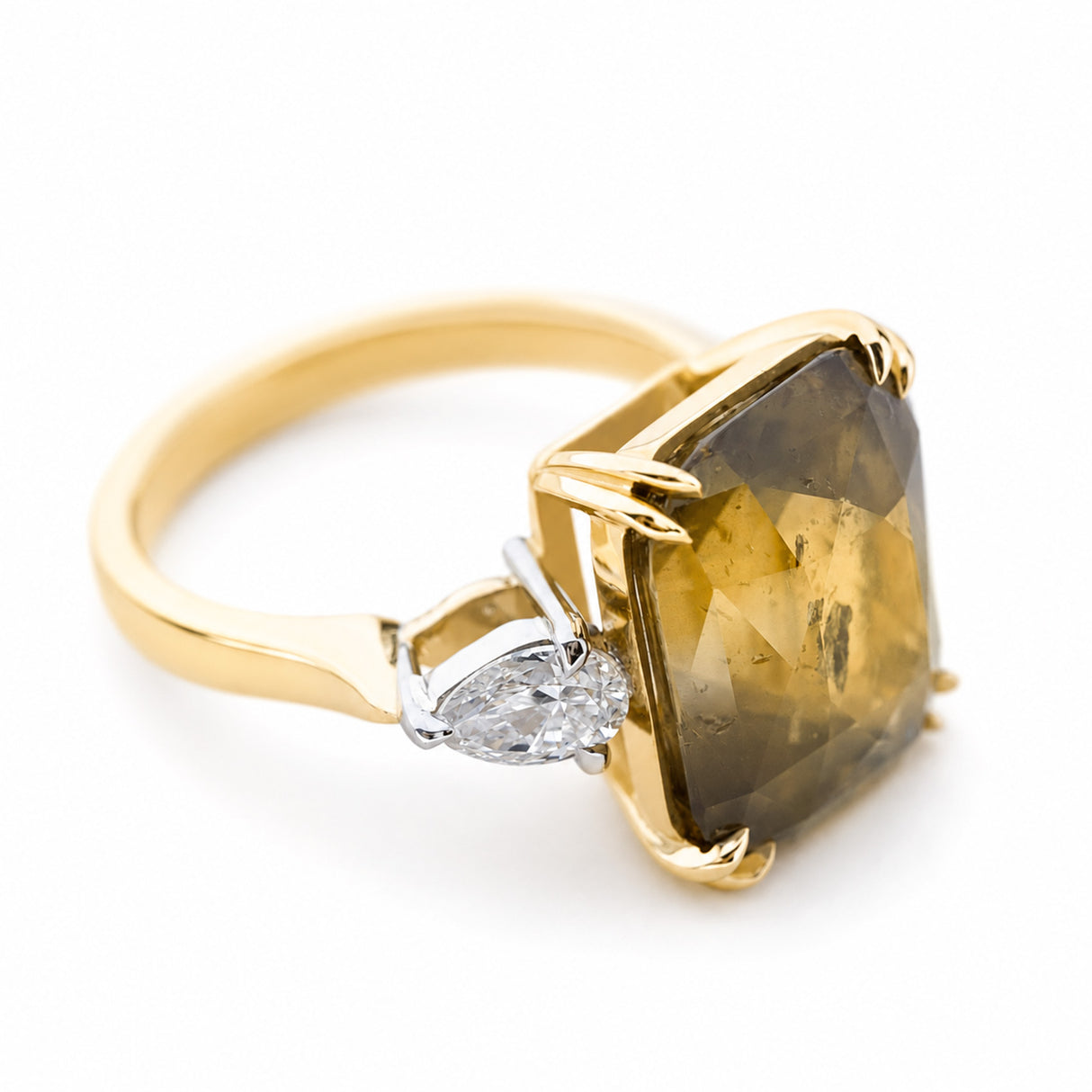 Angled view of a cushion-cut brown sapphire flanked by pear-shaped diamonds