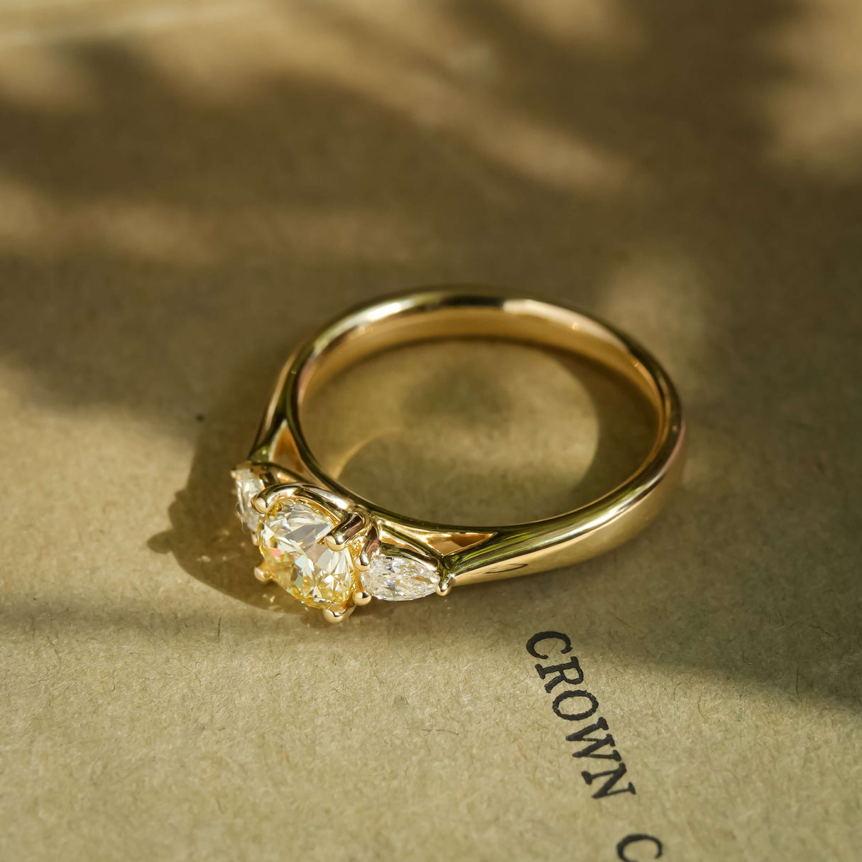 Champagne diamond with trillion side diamonds three stone engagement ring in yellow gold
