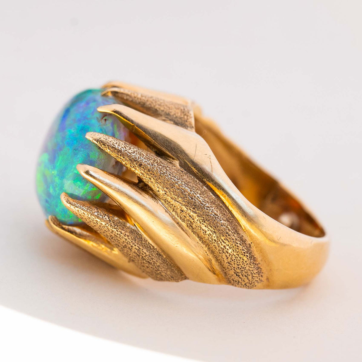 Side view of a vintage 1970s cabochon Australian opal ring in yellow gold.