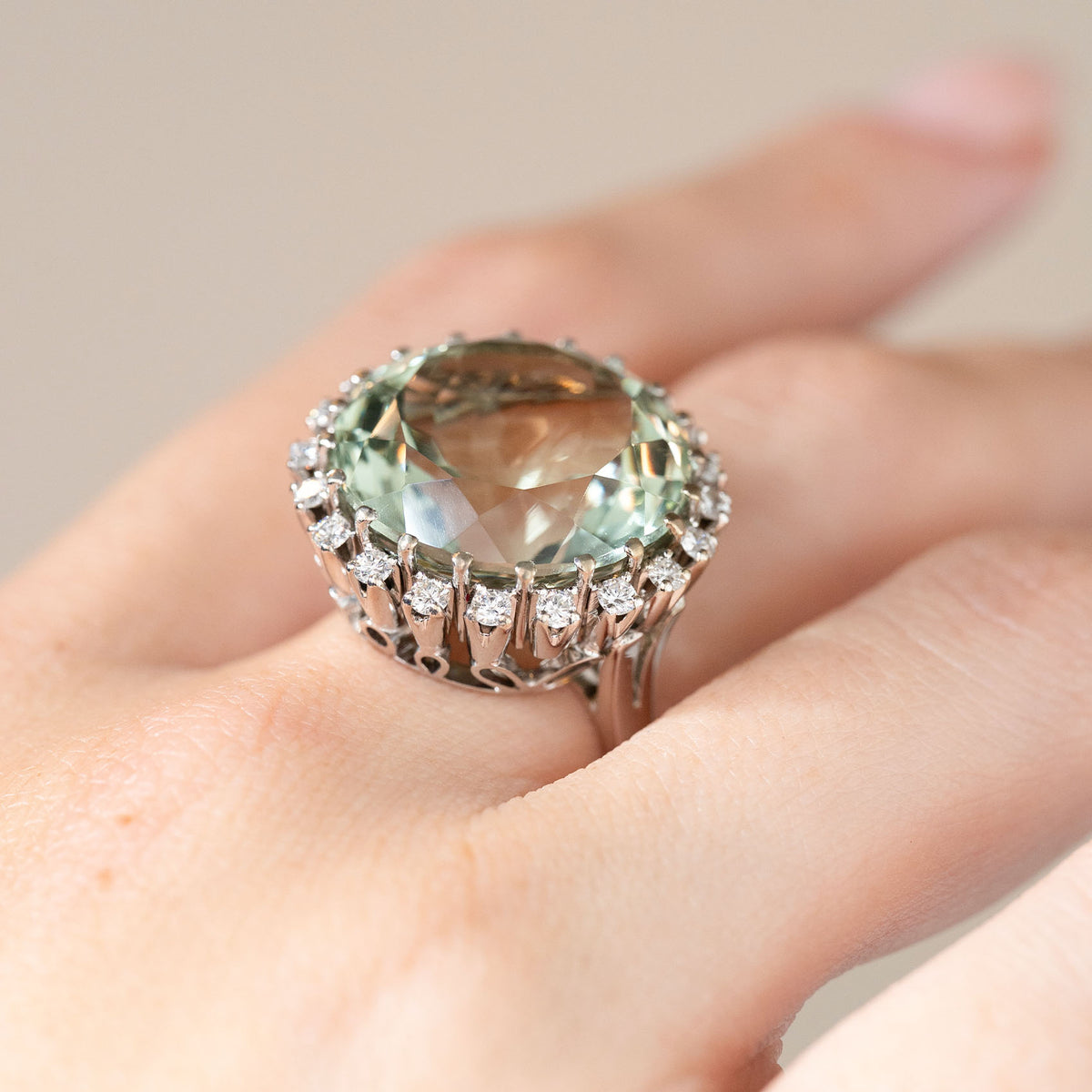 The vintage gemstone ring photographed at an angle on a hand, displaying its raised setting and large quartz.