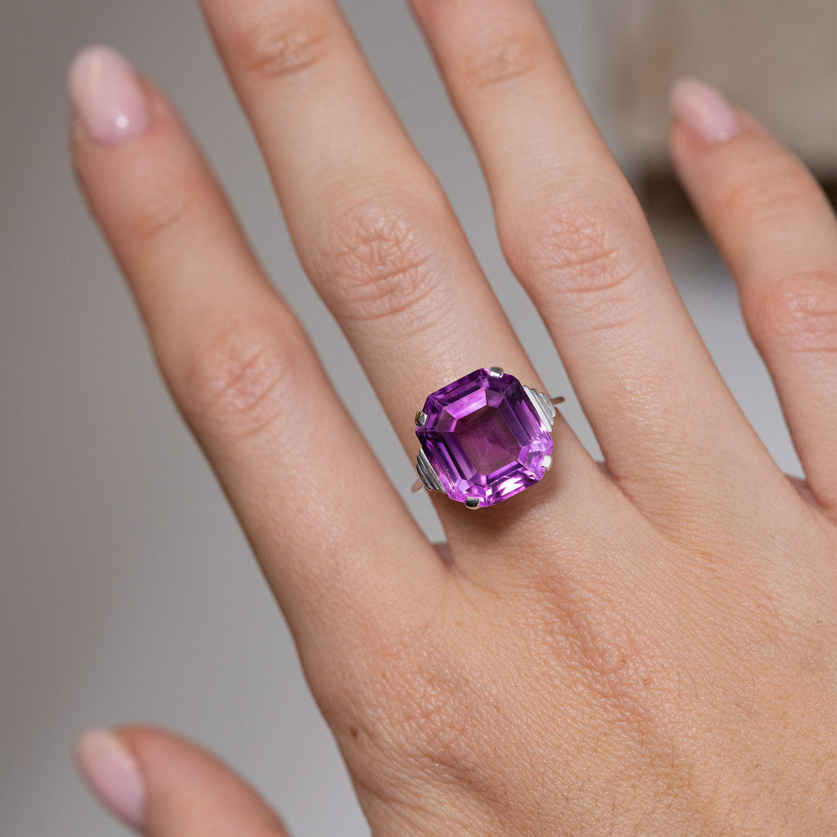 Purple amethyst cocktail ring worn on a hand, showcasing its striking gemstone and bold vintage proportions.