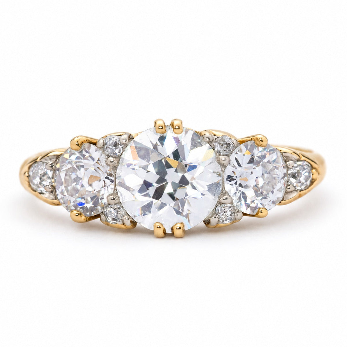 An antique, Victorian diamond half-hoop engagement ring in yellow gold with three round old-cut diamonds.