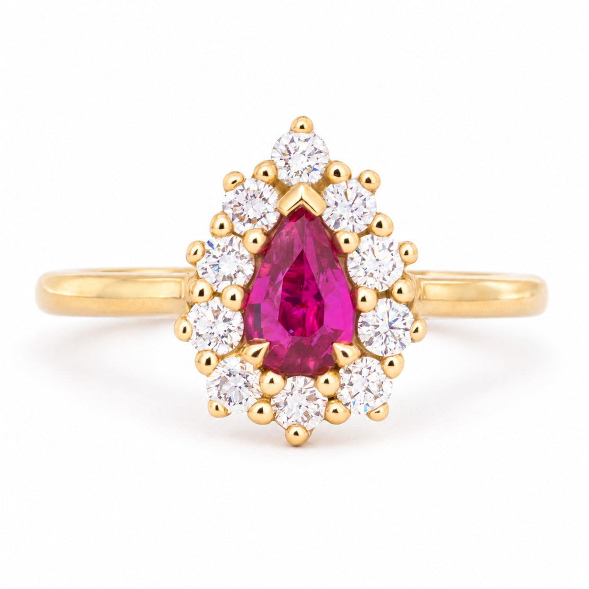 Vintage-inspired pear-cut ruby and diamond cluster engagement ring in polished yellow gold.