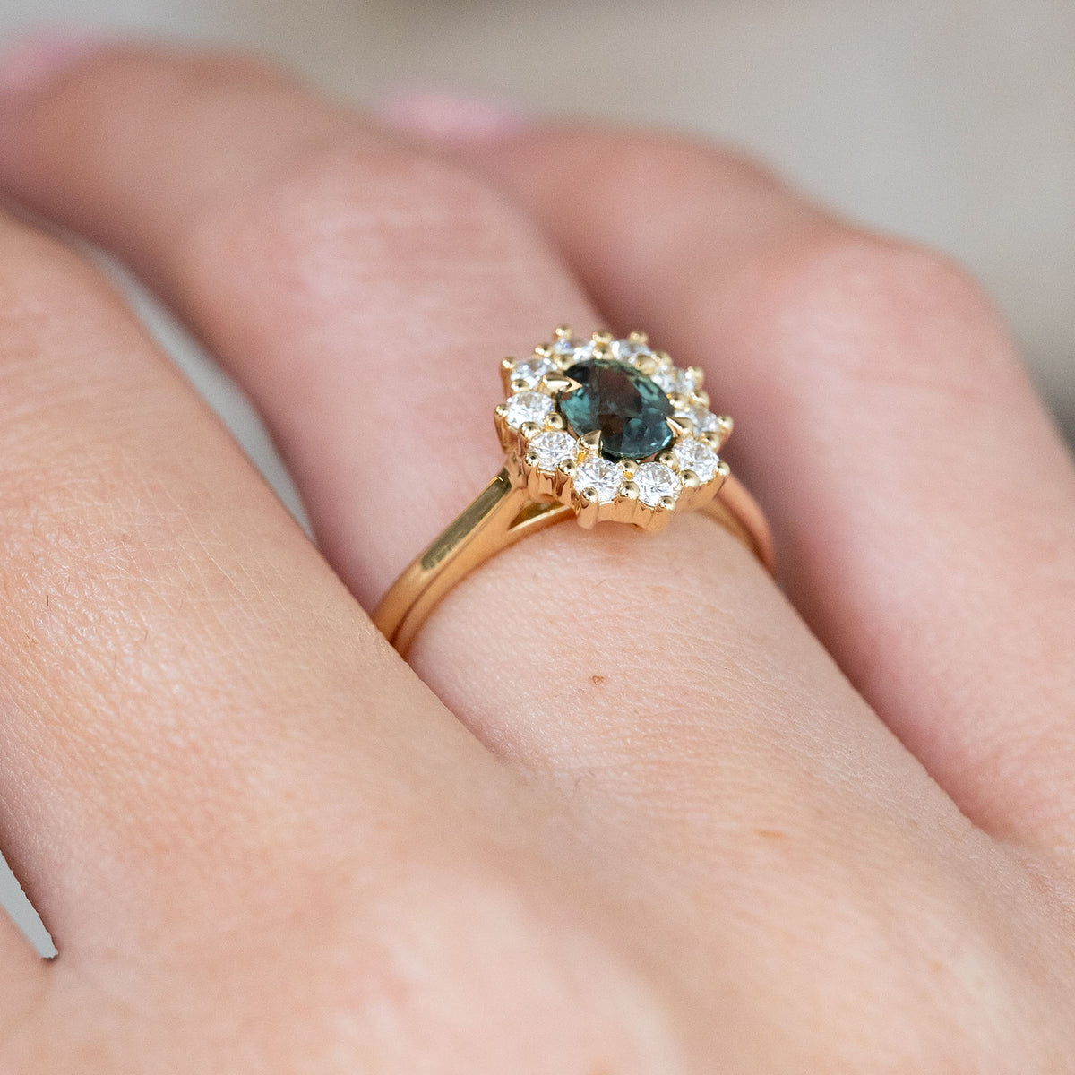 From an oblique angle, the raised yellow gold basket and sparkling diamond surround create a distinctive vintage-style silhouette.