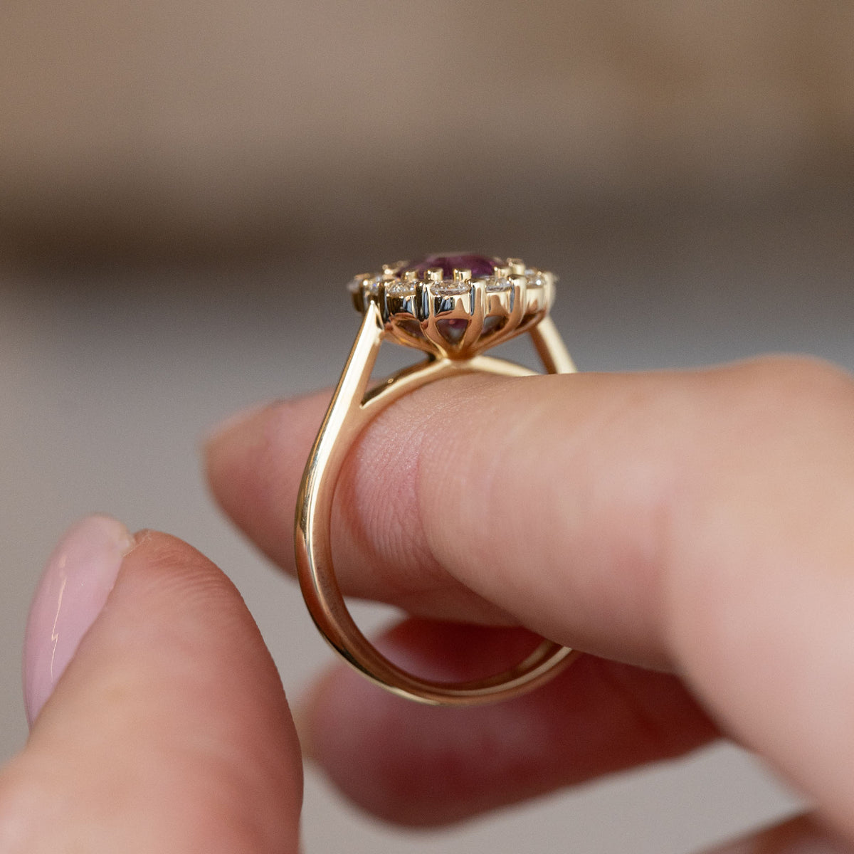 Side profile of the antique-inspired pink sapphire cluster ring, revealing the openwork gallery and polished yellow gold band.