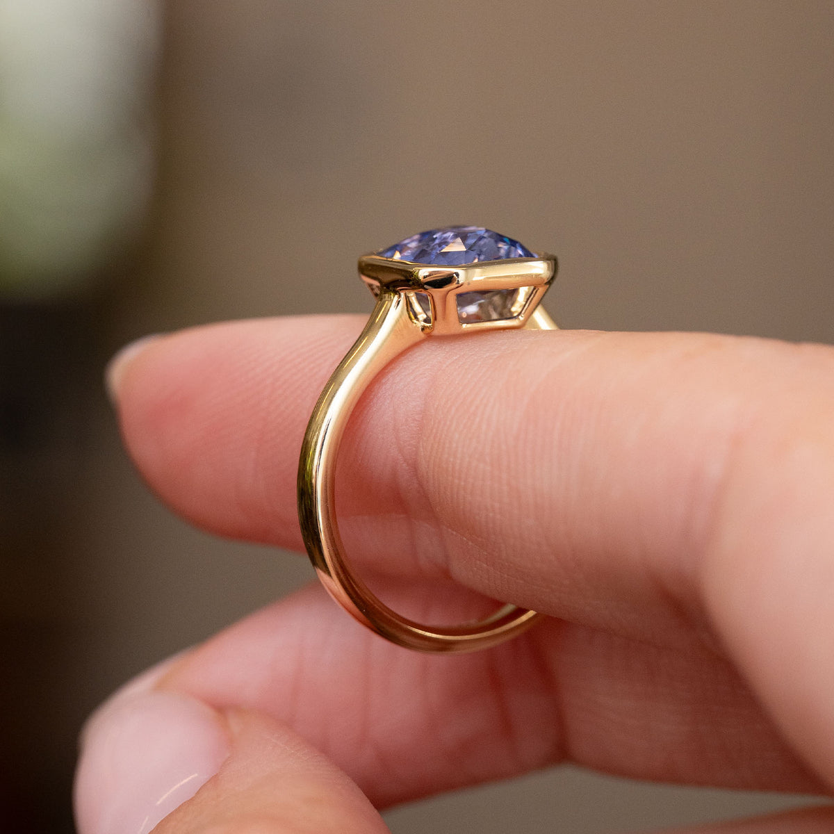 Side profile of the yellow gold engagement ring, showing its open basket and refined elevated setting.