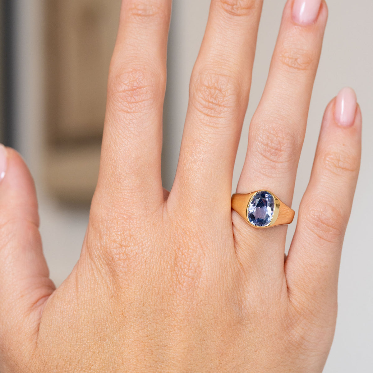 Antique Ceylon sapphire solitaire worn on the hand, revealing the gemstone’s shifting blue and violet tones.