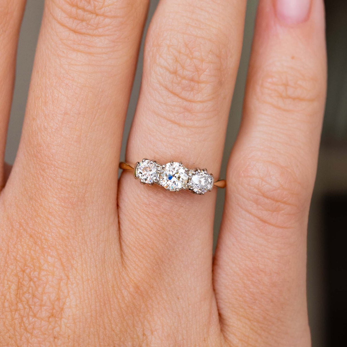 A close up picture of an Antique, Edwardian diamond trilogy yellow gold engagement ring