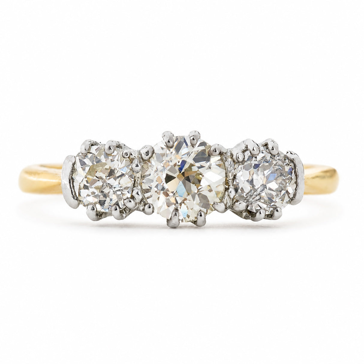 An antique, Edwardian engagement ring with three old-cut diamonds with a yellow gold band.