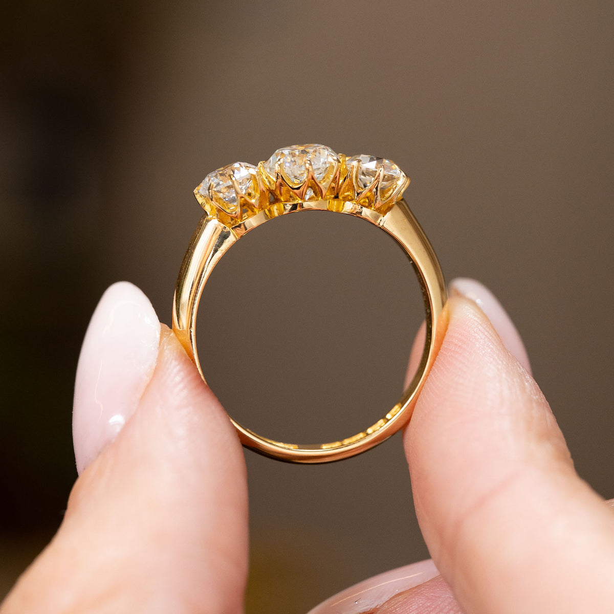 Profile view of a vintage 1930s diamond engagement ring, displaying the open claw gallery and polished 18ct yellow gold band.