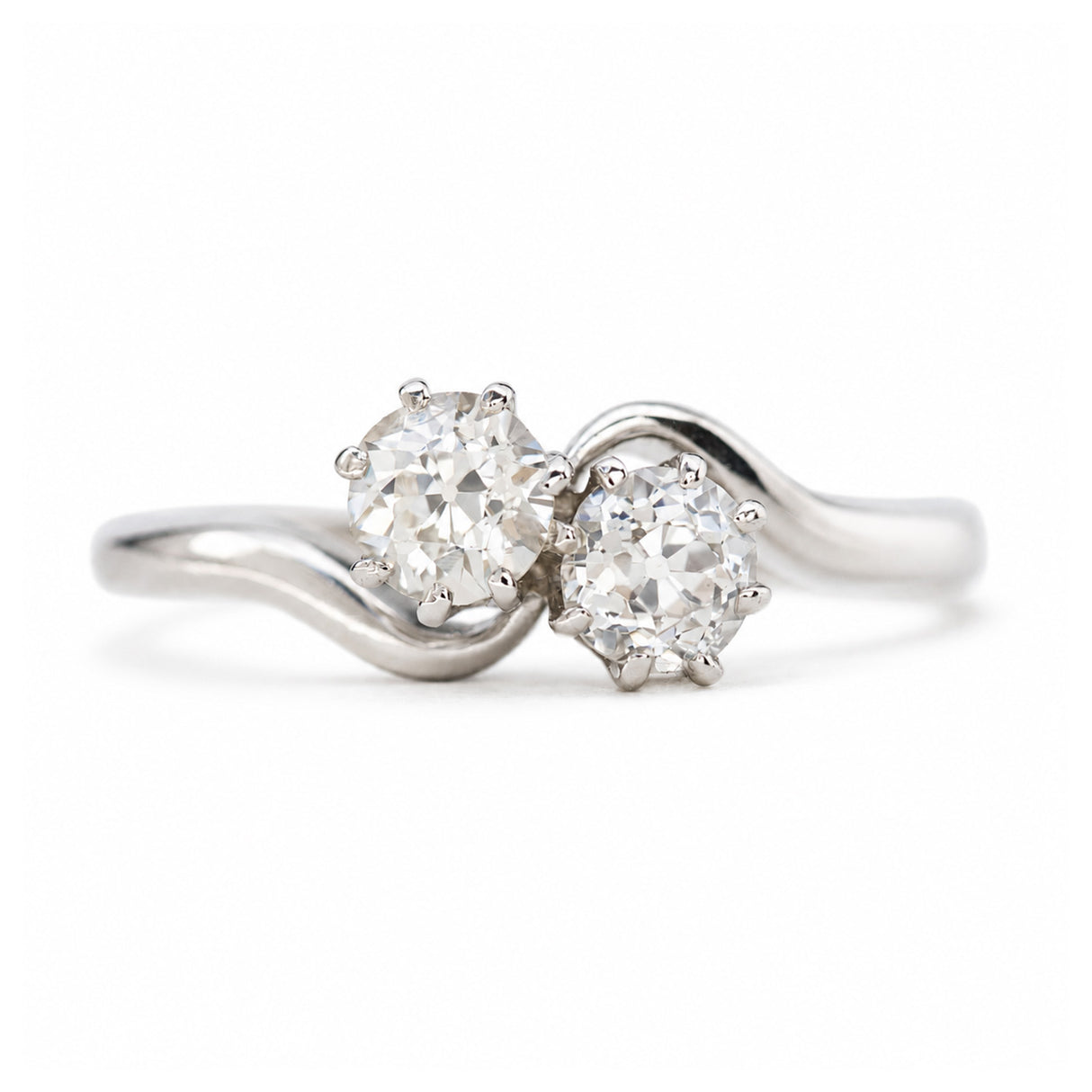 A platinum Antique, Edwardian toi et moi diamond engagement ring against a plain white background.