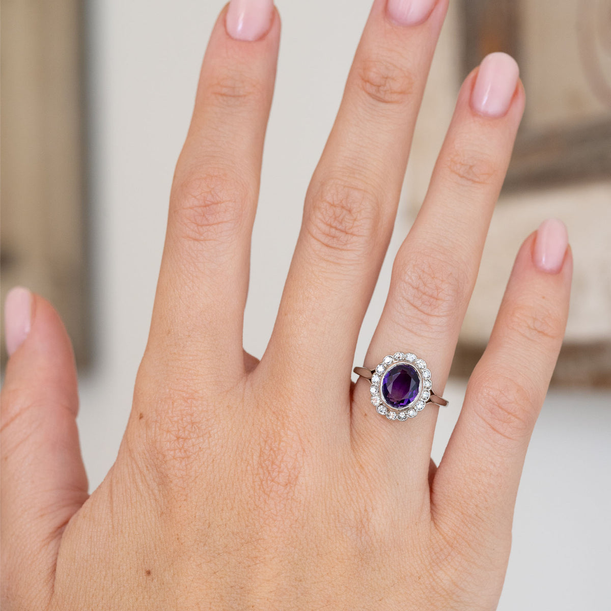 Seen on the hand, the Edwardian cluster ring combines a saturated purple centre stone with softly sparkling antique diamonds.