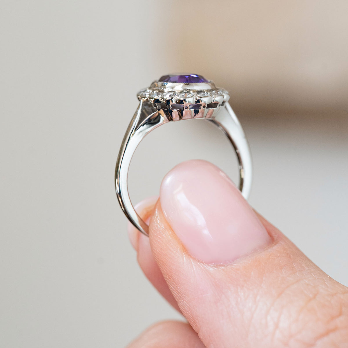 The side profile displays the elevated platinum gallery and graceful white gold band supporting the antique gemstone cluster.