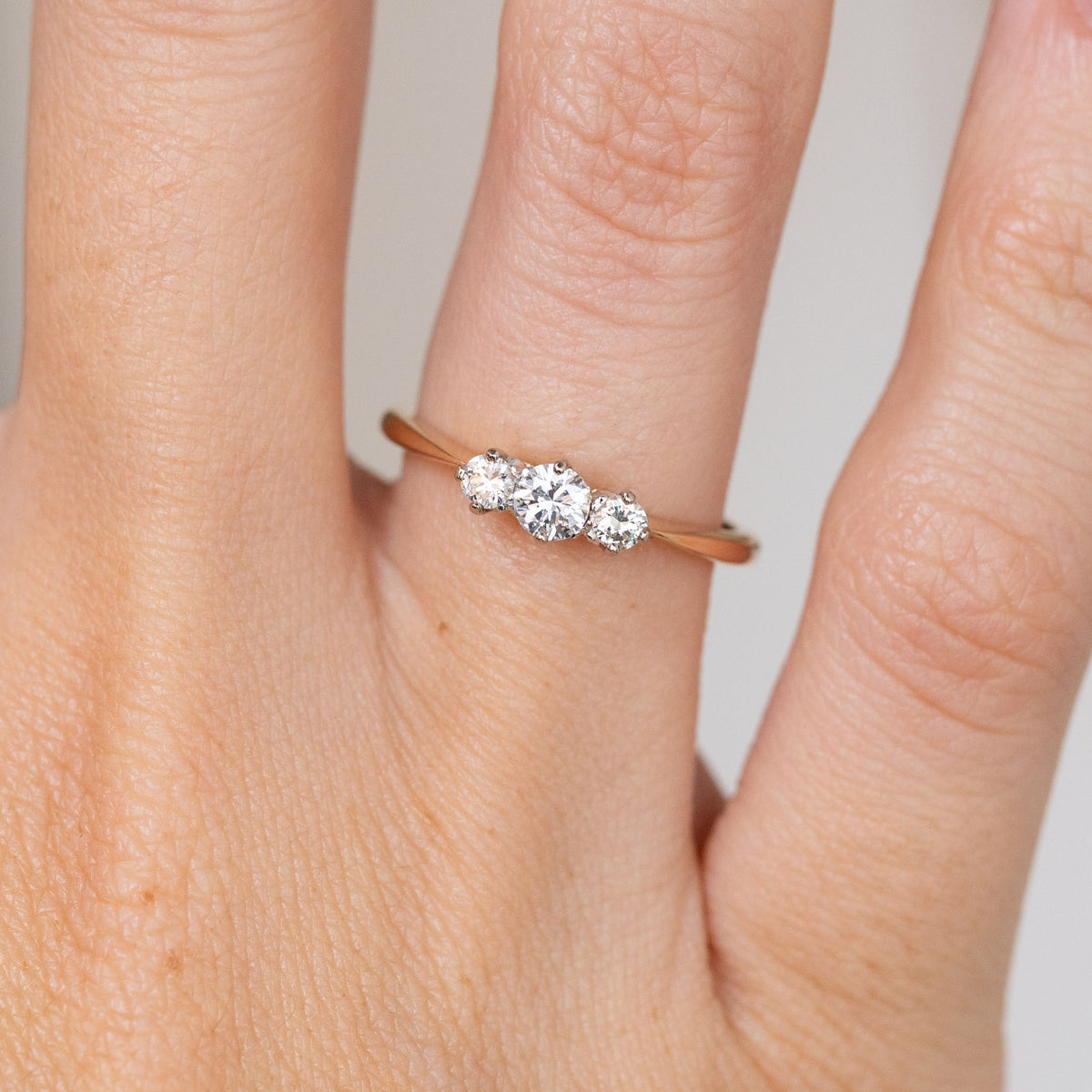 Close-up of the antique engagement ring, featuring a larger central diamond flanked by two matching side stones.