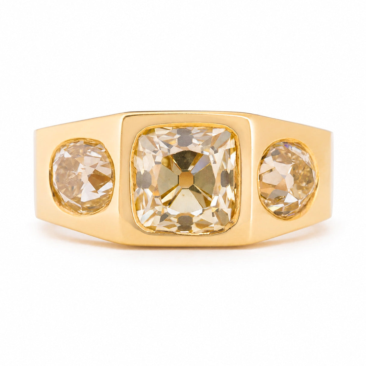 A Vintage, 1970s Peruzzi cut diamond three-stone gypsy ring in yellow gold against a white background.
