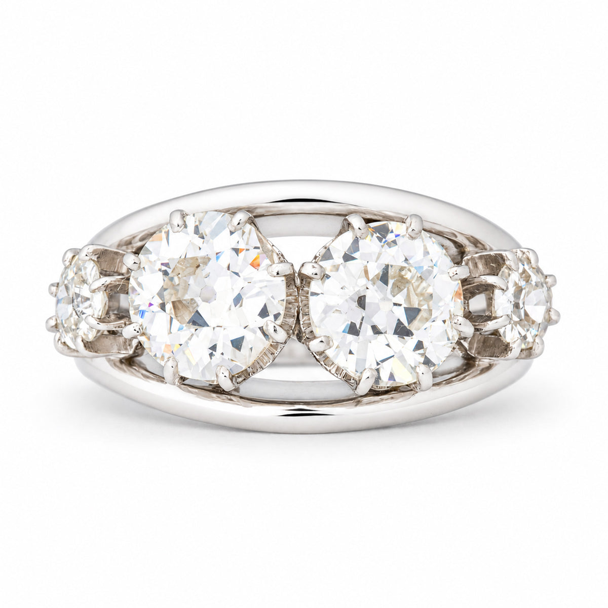 Vintage 1950s old-cut diamond four-stone engagement ring in white gold and platinum, featuring two larger central diamonds and smaller diamond shoulders.