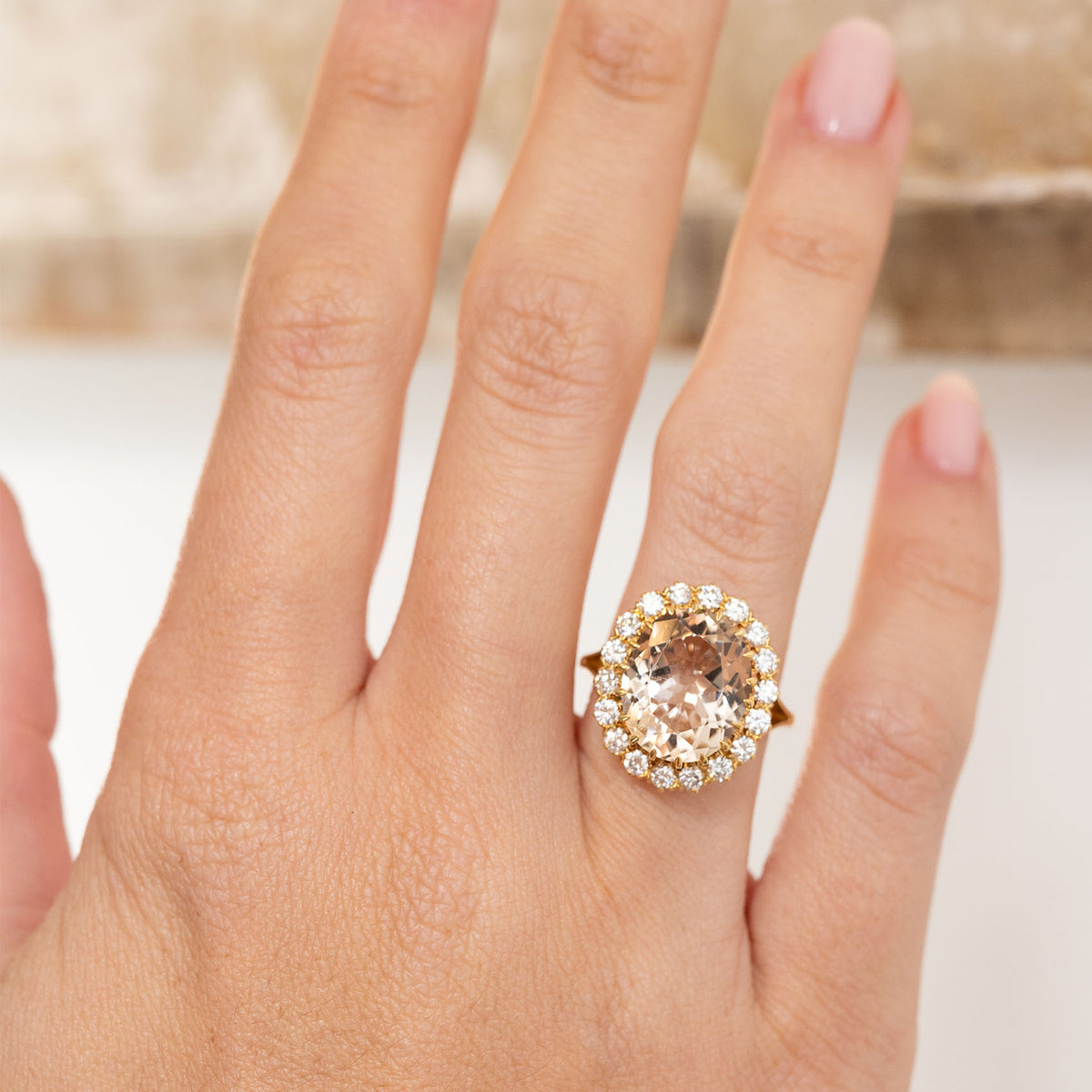 Vintage topaz and diamond engagement ring worn on the hand, showing the generous scale of its elegant oval cluster.