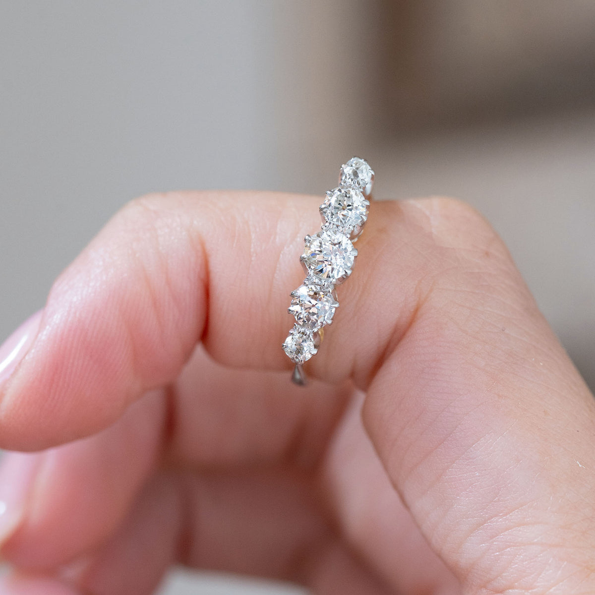 Held vertically between the fingers, the ring displays the individual old-cut diamond shapes and handcrafted claw settings.